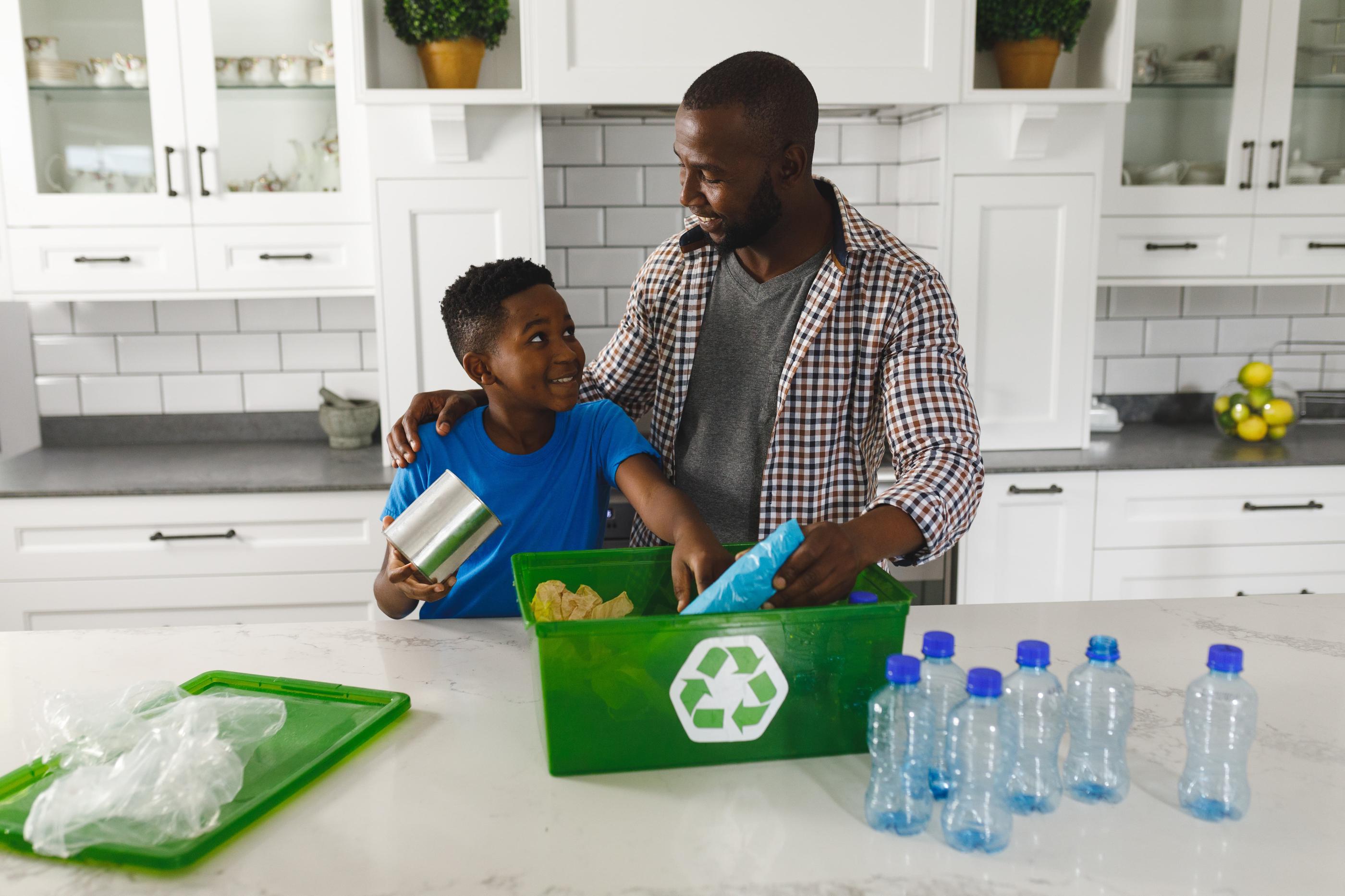 Father teaching his son how and what to recycle