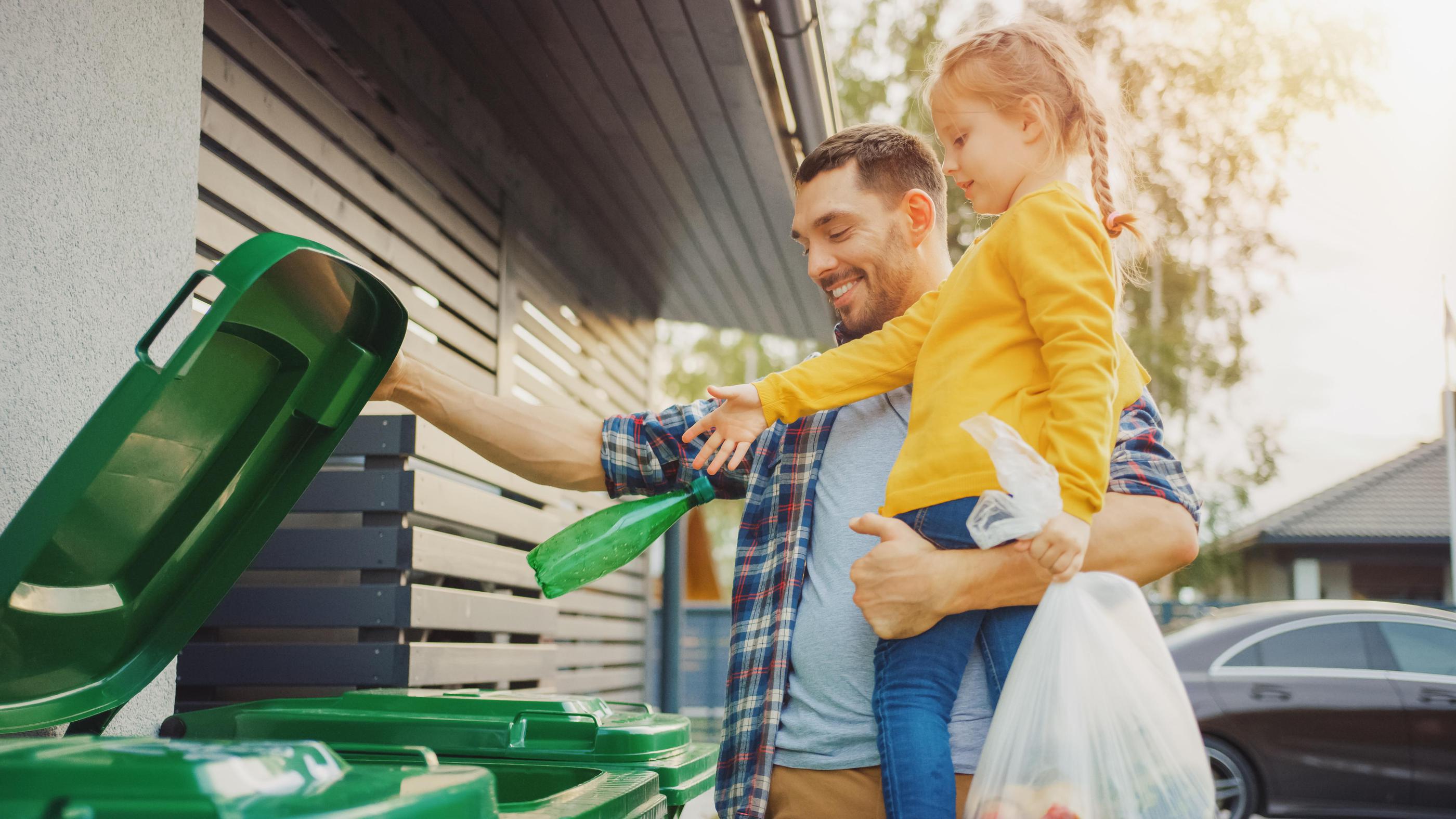 Father teaching his daughter how to recycle