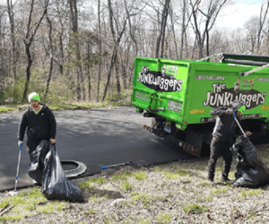 Junkluggers community service Junklugger employees picking up litter on side of road.