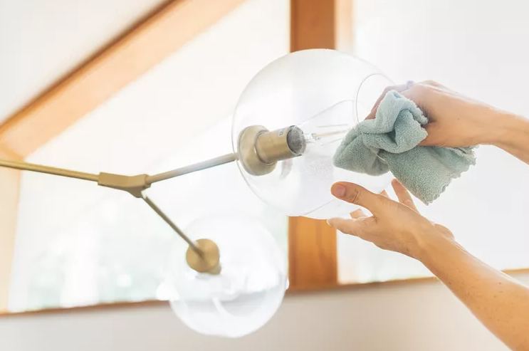 hand cleaning inside of glass chandelier 